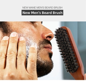 Detail of wooden beard brush with boar bristles applied to facial hair with shaving foam