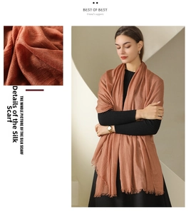 Detail of brick red cotton linen scarf showing soft texture and natural fringe edges