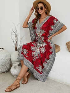 Detail of red Bohemian beach dress with ethnic print, V-neck, and loose flowy fabric