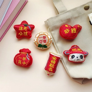 Dettaglio di ciondoli portafortuna ricamati per esami inclusi sacchetti e badge panda