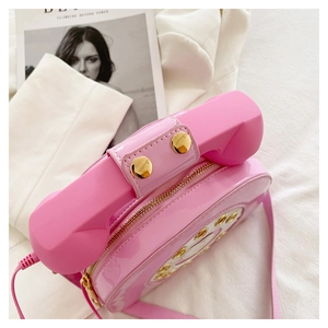 Top view of pink retro telephone crossbody bag with glossy finish and gold hardware details