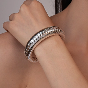 Close-up of a silver-toned chunky open cuff bracelet with unique spiral ribbed texture