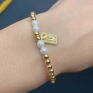 Detailed shot of beaded bracelet with Virgin Mary pendant and pearls on the wrist
