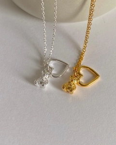 Detail of cute S925 silver bear and hollow heart pendants in gold and silver finishes