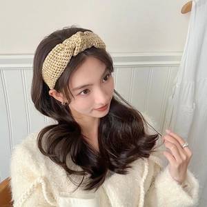 Détail du serre-tête tressé beige clair avec un design à nœud torsadé sur modèle
