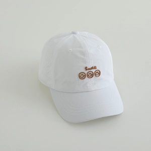 Detail view of white kids baseball cap featuring breathable mesh and brown smile embroidery