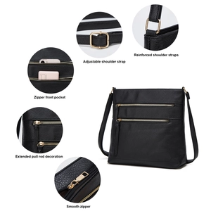 Detail view of black faux leather crossbody bag with golden zippers and adjustable strap