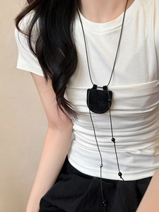 Detail of a black faux suede semi-circle magnetic glasses holder necklace on a model