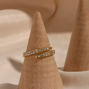 Close-up of 18k gold plated zircon open ring on a wooden display with silk fabric