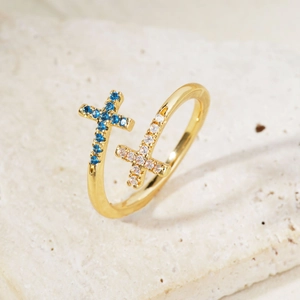 Macro shot of double cross open ring with blue and white zircons on natural stone