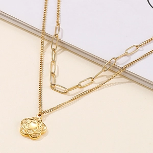 Detailed shot of double-layer gold necklace with paperclip chain and hollow flower pendant