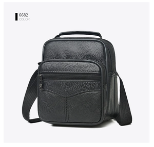Close-up of black leather crossbody bag featuring a textured lychee grain finish