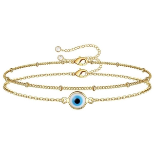 Close-up of golden double-layer chain bracelet with evil eye charm and bead details