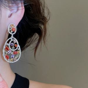 Close-up of multicolor zircon teardrop earrings with gold finish on a model