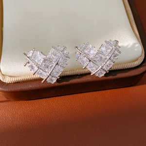 Gros plan de boucles d'oreilles cœur en argent serties de zircons carrés brillants