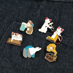 Set of six cute cat and polar bear enamel lapel pins on a dark blue denim jacket