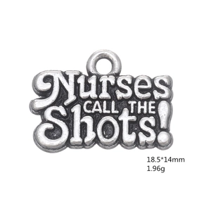 Macro detail of silver nurse hat pendant engraved with Nurses CALL THE Shots text
