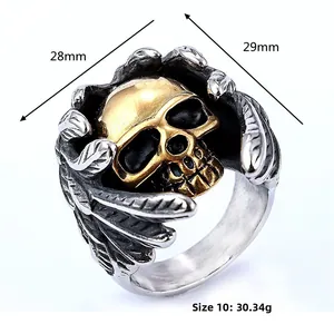 Vue détaillée d'une bague punk en argent avec crâne doré et gravures d'ailes précises