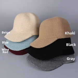 Détail de casquettes de baseball en tricot empilées en beige, bleu, bordeaux et kaki