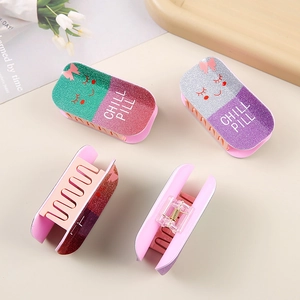 Flat lay of colorful glittery hair clips with CHILL PILL text and bow design