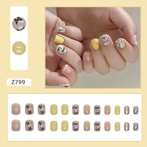 Short yellow glitter press-on nails set with star patterns and Good Luck bear design