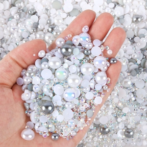 Close-up of mixed white and AB resin pearls and rhinestones for DIY nail art and crafts