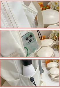 Detail of the reinforced stitching on white nylon backpack straps and side storage pockets