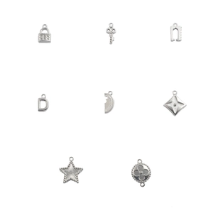 Macro view of assorted silver stainless steel star, key, and lock charms for DIY jewelry