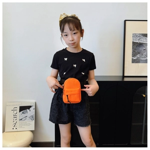 Detail of vibrant orange nylon mini waist bag for kids with adjustable black strap