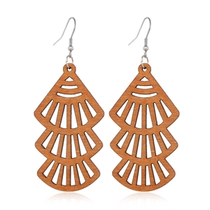 Detailed macro view of three-tier hollowed wood fan earrings with natural grain texture