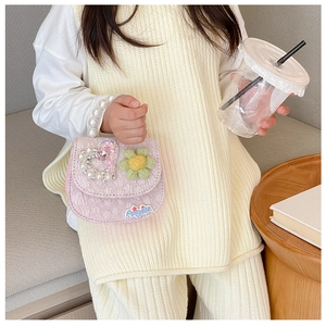 Detail of pink children's handbag featuring pearl handle and sparkling heart gem decor