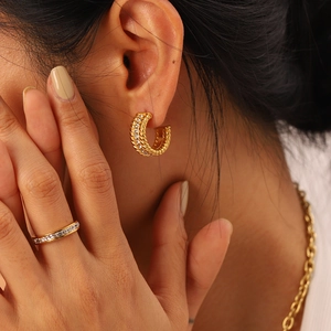 Eleganti orecchini a cerchio ritorti dorati e anello pavé con pietre di zircone