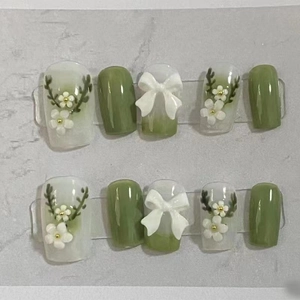 Handmade gradient green press-on nails with 3D white bows and floral vine decorations
