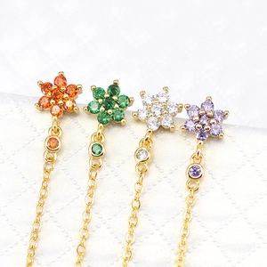 Macro shot of s925 chain earrings with flower zircon in orange, green, white, and purple