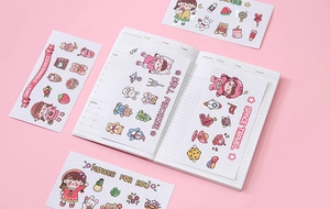 Flat lay of cute cartoon PVC sticker sets with strawberry and space themes for journals