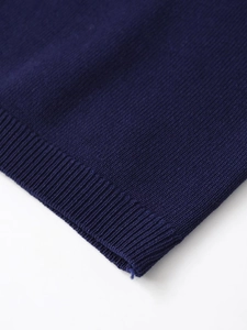 Detail of navy blue fine knit short sleeve jacket featuring ribbed cuffs and high-quality wool