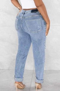 Detail view of high waist light blue denim jeans with rolled cuffs and straight leg fit