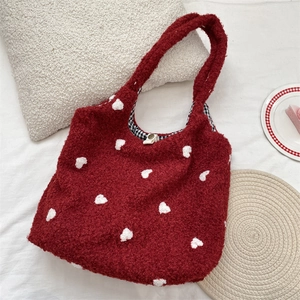 Detail of burgundy fleece tote with heart embroidery and black-white checkered lining