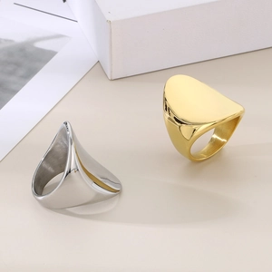 Close-up of gold and silver chunky oval rings with a polished minimalist metallic finish