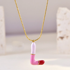 Detail of gold chain necklace featuring an L-shaped lipstick pendant in pink and purple enamel