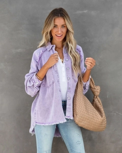 Detailansicht der lila Jeansjacke mit Fransen und gewebter Lederhandtasche für Damen