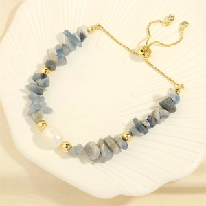 Detail of irregular blue stone stretch bracelet with freshwater pearl and gold beads