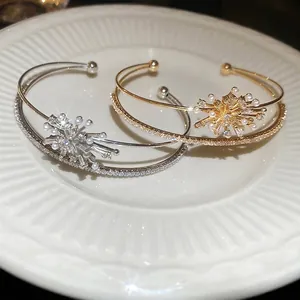 Elegant gold and silver firework bracelets with pearls and zircons on a white plate