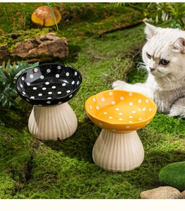 Detail of mushroom-shaped ceramic cat bowls on a mossy forest-themed decorative base