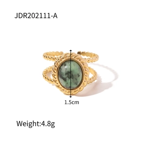 Detail of vintage gold dual-band open ring featuring green oval stone and twisted texture