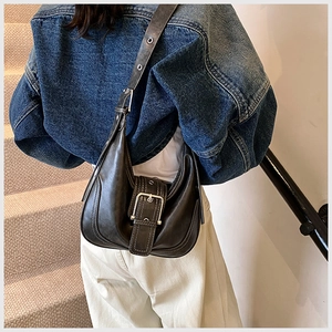 Detail der Vintage-Schultertasche aus Kunstleder mit Metallschnalle und Ösenriemen