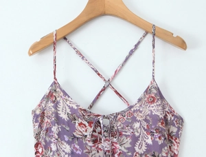 Détail d'une robe violette à motif paisley avec fines bretelles croisées et nœud devant
