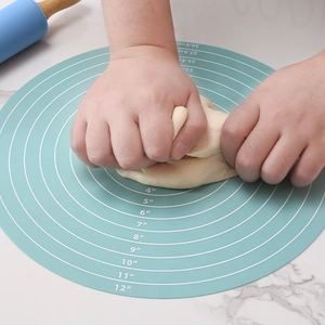 Light blue 30cm circular silicone kneading mat with measurements shown in use