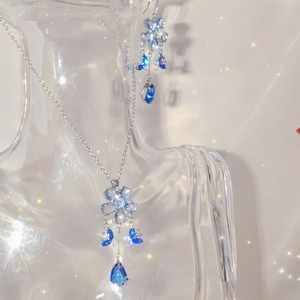 Detailed shot of blue butterfly earrings and necklace set with sparkling teardrop crystals