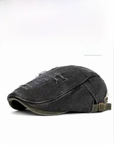 Détail d'un béret noir vieilli avec points de croix rouges et boucle en métal bronze